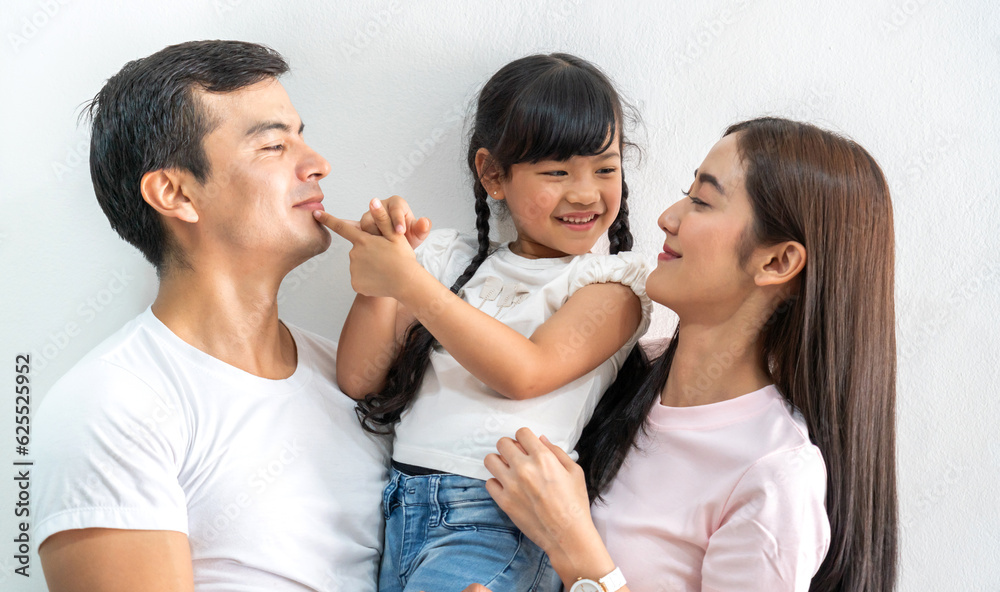 Portrait of enjoy happy love asian family father and mother holding hug cute little asian girl child smiling play and having fun moments good time, care, kid, support, insurance, child, at home Portrait of enjoy happy love asian family father and mother holding hug cute little asian girl child smiling play and having fun moments good time, care, kid, support, insurance, child, at home