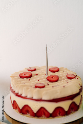 white cake with strawberries on the table