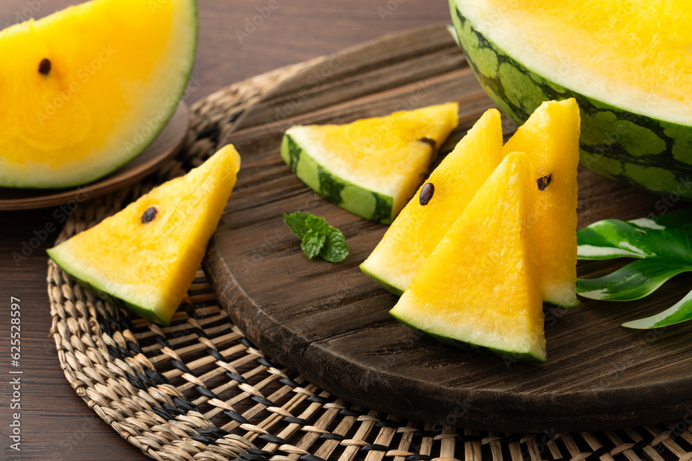 Sliced yellow watermelon in a plate on wooden table background. Sliced yellow watermelon in a plate on wooden table background.