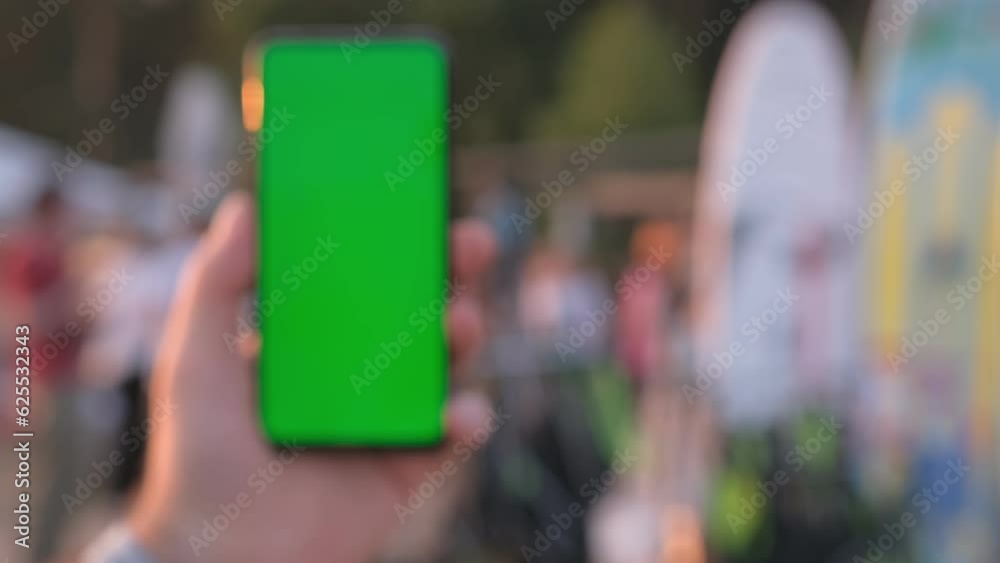 Sup rental on the beach. Female hand with smartphone with green screen mockup on tropical beach background at sunset on summer vacations Sup rental on the beach. Female hand with smartphone with green screen mockup on tropical beach background at sunset on summer vacations
