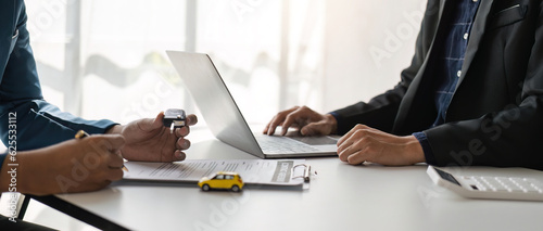 signing car insurance document or lease paper. Writing signature on contract or agreement. Buying or selling new or used vehicle. Car keys on table. Warranty or guarantee. Customer or salesman