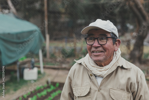 a man in his 70s smiling in his vegetable garden in winter