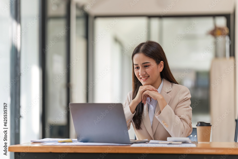 Young happy professional business woman working on laptop in office sitting at desk, female company manager executive portrait at workplace Young happy professional business woman working on laptop in office sitting at desk, female company manager executive portrait at workplace