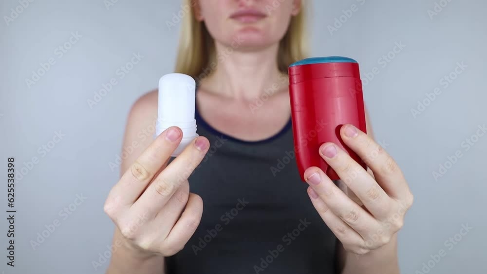 left or right. Girl chooses between eco-friendly deodorant without toxins and antiperspirant with toxic elements. In left hand Mineral alum crystal stick, in right hand classic remedy chemical nature
