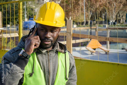 young man civil engineer of african ethnicity communicating on the phone