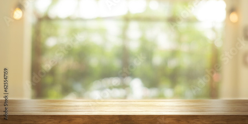Empty wooden table top with blurred coffee shop or restaurant interior background. Panoramic background. © n.ko.studios