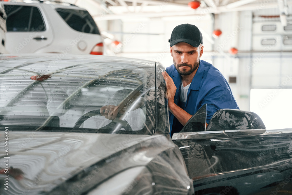 Dirty car is moved by auto mechanic that is in garage. Repair service Dirty car is moved by auto mechanic that is in garage. Repair service