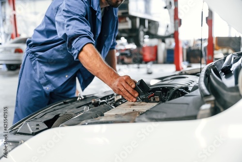 Troubleshooting process. Auto mechanic working in garage. Repair service