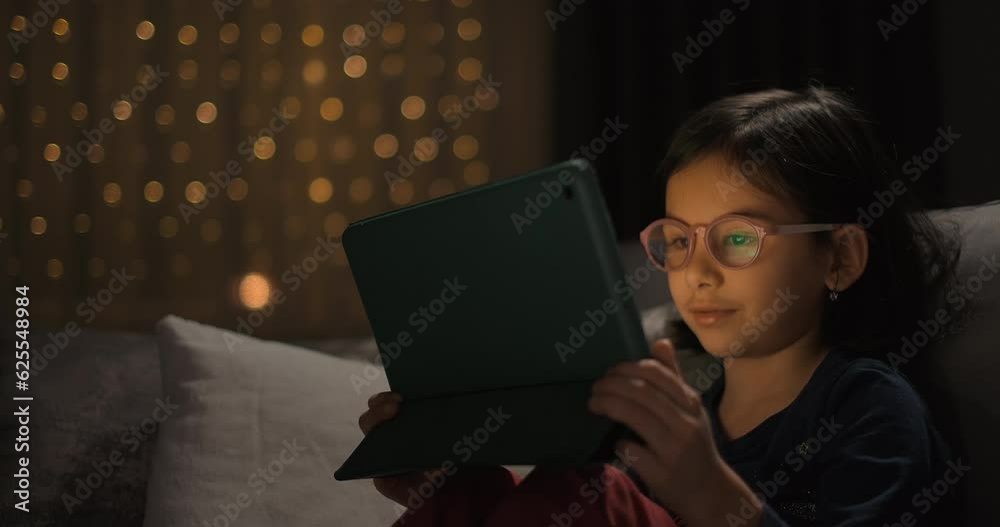 Cute girl is using digital tablet. Concept of storytelling and streaming television show Cute girl is using digital tablet. Concept of storytelling and streaming television show