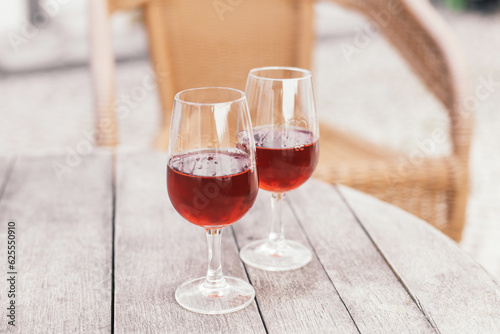 Two glasses of alcoholic beverage - Portuguese sweet wine Moscatel on a wooden table in a vineyard cafe terrace 