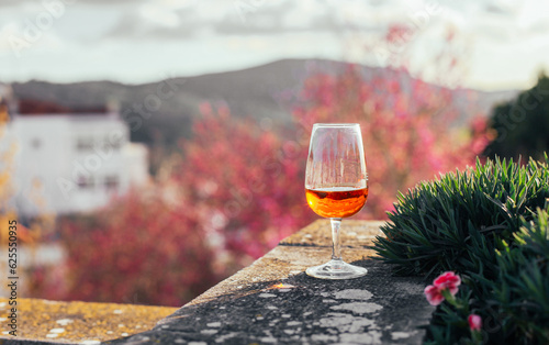 Wallpaper Mural A glass of orange beverage - Moscatel de Setubal on a terrace with trees view, sunset, Portugal Torontodigital.ca