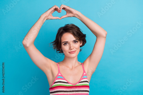 Photo of young activist girl wear striped stylish top showing heart sign sympathy charity foundation isolated on blue color background © deagreez