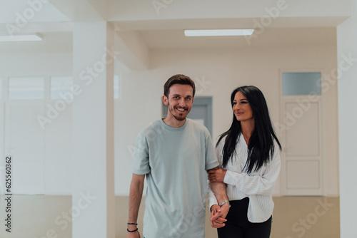 Youn in love students exchange tender emotions while embracing in the university hallway, capturing the essence of their affectionate and joyous relationship during their college days.