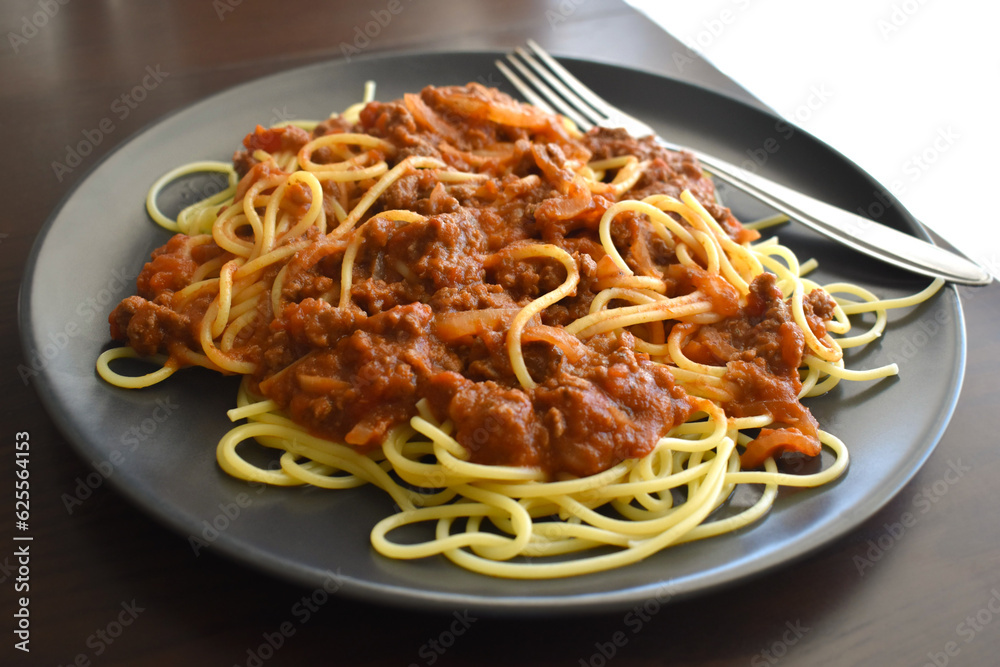 Spaghetti Bolognese with minced beef, onion, chopped tomato, garlic, olive oil, stock cube, tomato puree and Italian herb. Traditional Italian food. Spaghetti Bolognese with minced beef, onion, chopped tomato, garlic, olive oil, stock cube, tomato puree and Italian herb. Traditional Italian food.