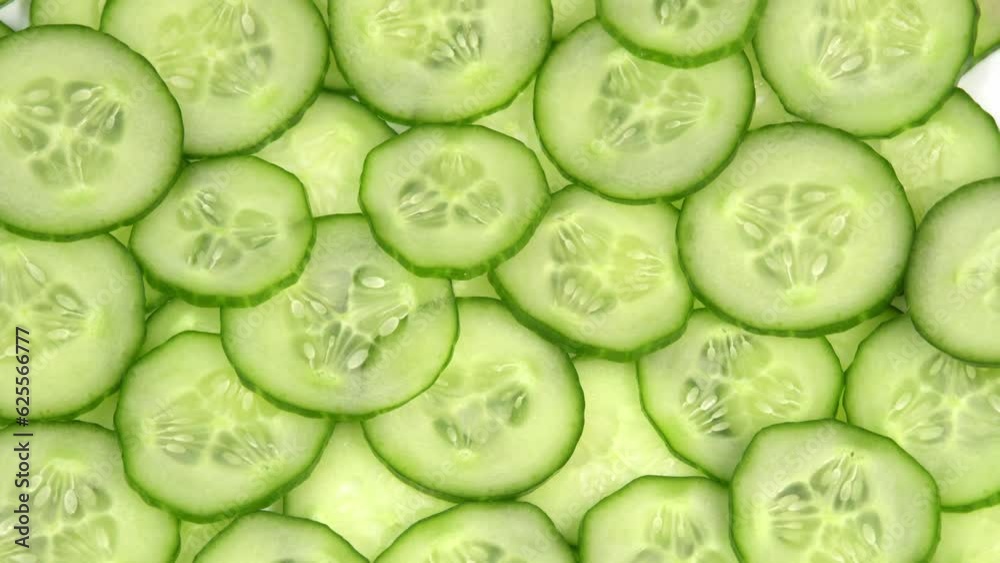 Top view fresh cucumber cut into slices rotate. Background of chopped cucumber slices for cooking show, restaurant, cafe, fast food. Moisturizing the skin and smoothing wrinkles
