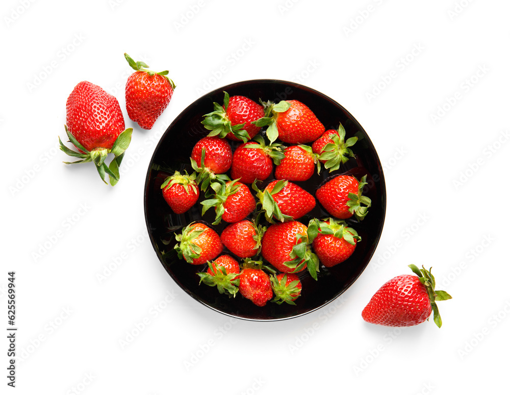 Berries of organic strawberries in a black round plate isolated on white background, top view. Berries of organic strawberries in a black round plate isolated on white background, top view.