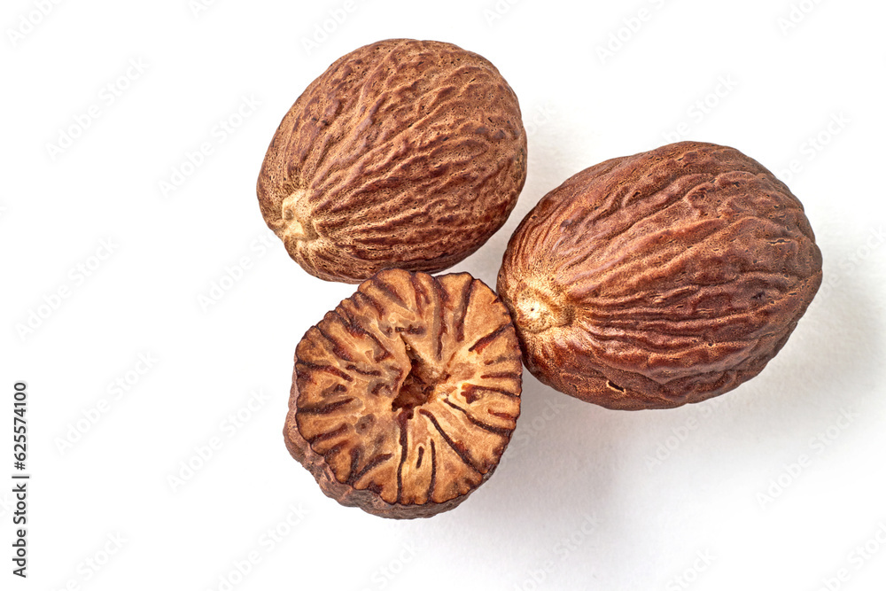 Three nutmegs, whole and half, isolated on white background Three nutmegs, whole and half, isolated on white background