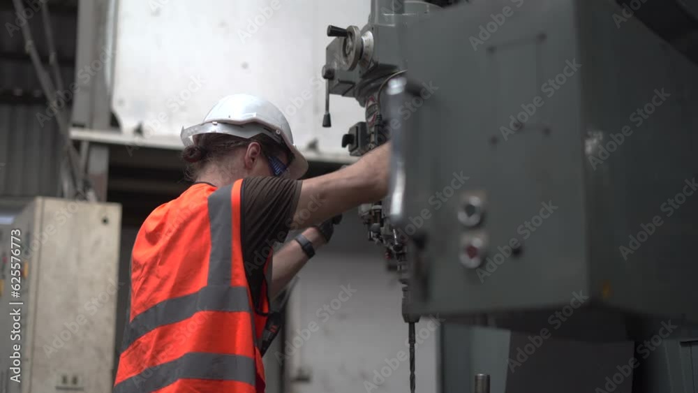 industrial Engineer man control lathe machine to drill components in industry manufacturing large factory . caucasian labor worker male in hard hat and goggles working metal work in workplace . industrial Engineer man control lathe machine to drill components in industry manufacturing large factory . caucasian labor worker male in hard hat and goggles working metal work in workplace .