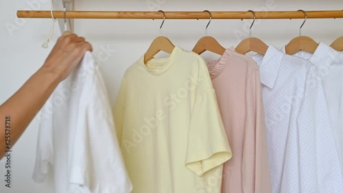Unrecognizable woman hangs clothes on a hanger