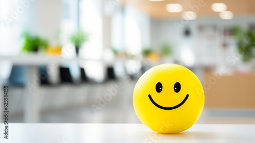 Positivity in the workplace with a yellow smiling smiley ball in the office interior, promoting a positive work environment