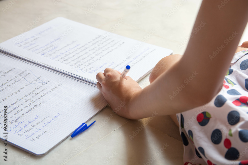 Close up de manos de estudiante escribiendo en una libreta en vacaciones. Zurdos. Close up de manos de estudiante escribiendo en una libreta en vacaciones. Zurdos.