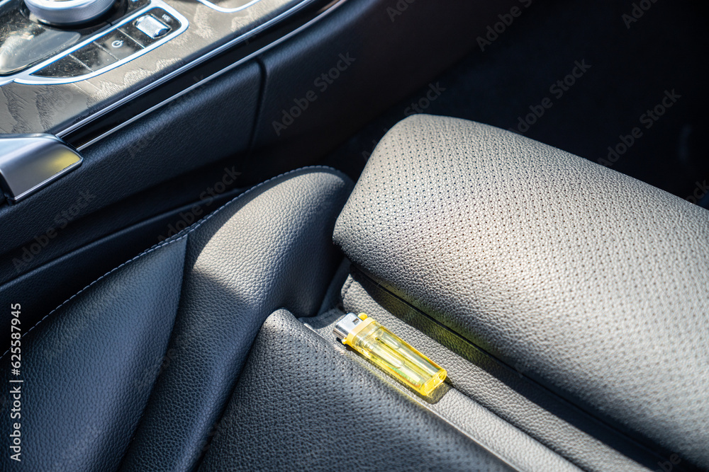 Lighter in car on hot sunny day. High temperatures in summer can cause
