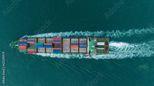 aerial top view Cargo Ship carrying container and running for export goods from cargo yard port to other ocean concept freight shipping ship