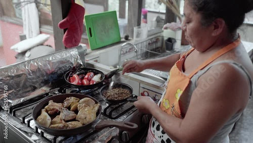 Una mujer Hispana adulta está calentando sésamo y pipas para preparar mole