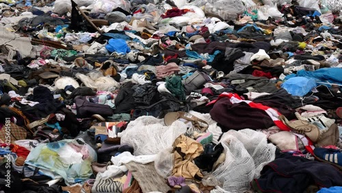 Video footage of a textile dump outdoors. Problems with an overabundance of unsold products.