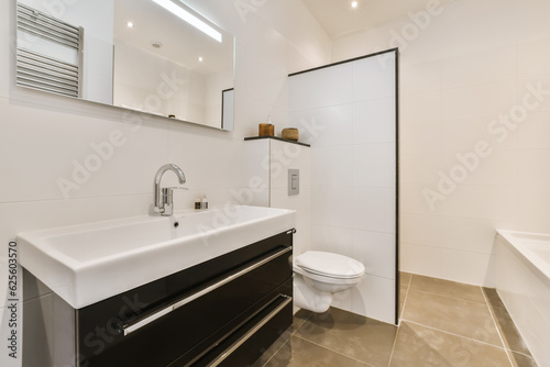 a modern bathroom with black and white fixtures on the vanity, toilet and bathtub in the wall is made of glass