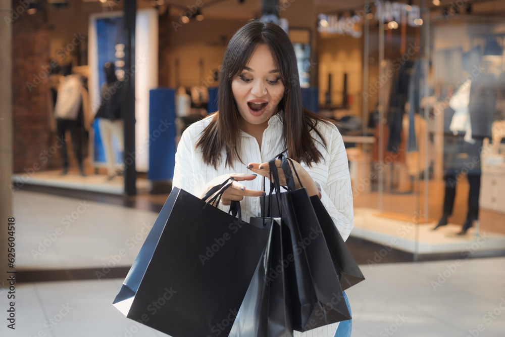 Young plus size shopaholic woman saw the check and surprised and shocked by the many purchases in the shopping mall Young plus size shopaholic woman saw the check and surprised and shocked by the many purchases in the shopping mall