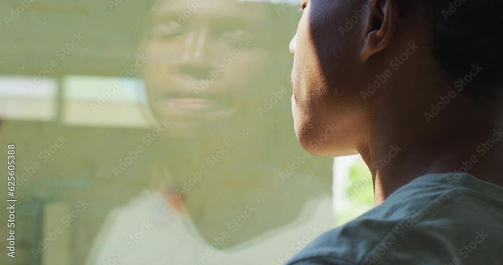African american man looking at the window and drinking coffee at home African american man looking at the window and drinking coffee at home