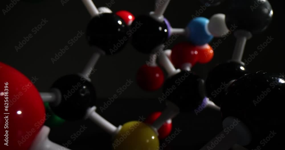 Multi-colored molecular connections on black background in dark premise. Detailed atomic structure concept. Chemistry science and education