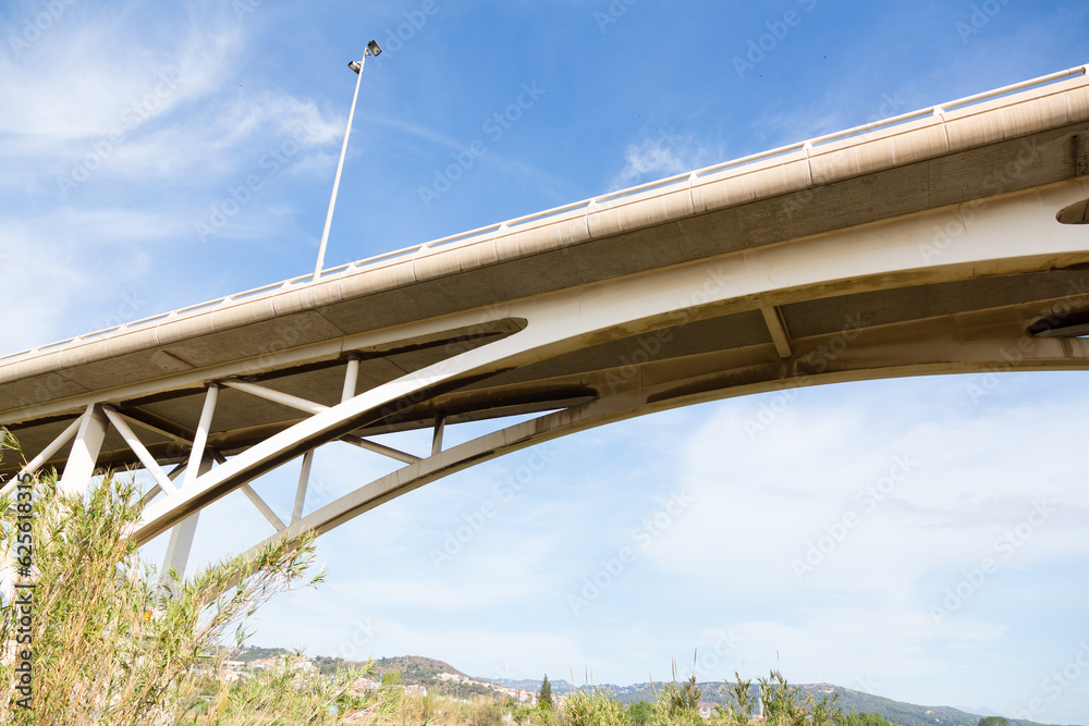 Modern bridge with several arches crossing a river Modern bridge with several arches crossing a river