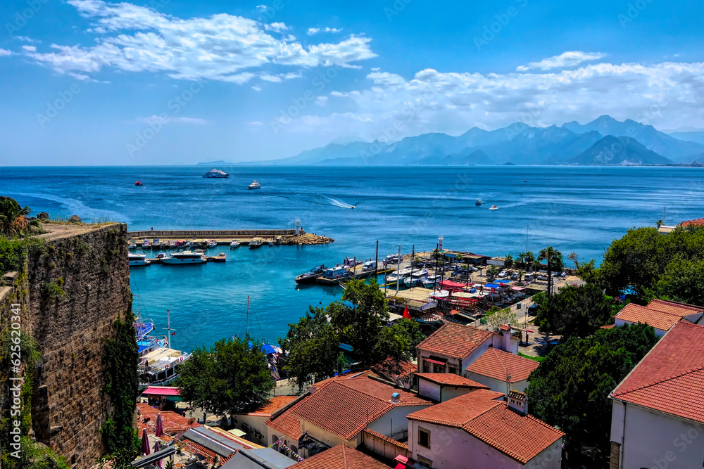View to sea and mountains from historic old town of Kaleici Antalya Turkey with boats and harbour walls