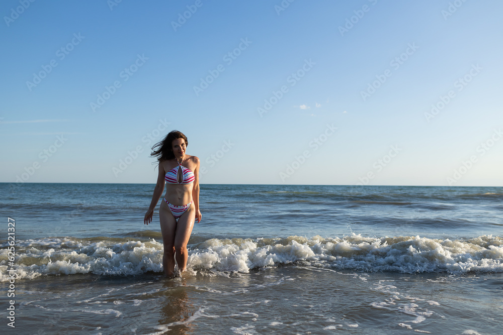 Beautiful brunette woman wearing swimsuit in sea have fun