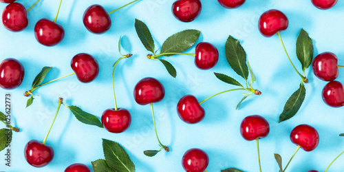 Red cherry on blue background. Ripe red cherry berries as background. Flat lay  top view  copy space