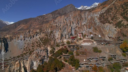 Aerial revealing view Bhraka village houses with stupa on hilltop. Manang district. Annapurna mountain region. Himalayas mountain villages architecture and nepalese culture. photo