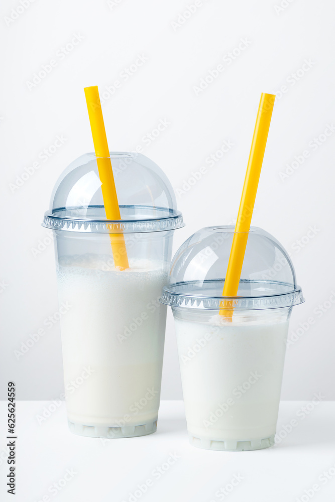 Two milkshakes in the transparent plastic glasses Two milkshakes in the transparent plastic glasses