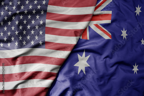 big waving colorful flag of united states of america and national flag of australia .