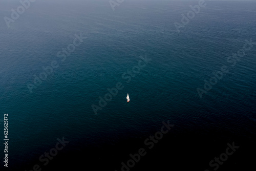 Aerial view of a boat sailing the blue Mediterranean Sea water in summer, Peniscola, Castello, Spain. photo