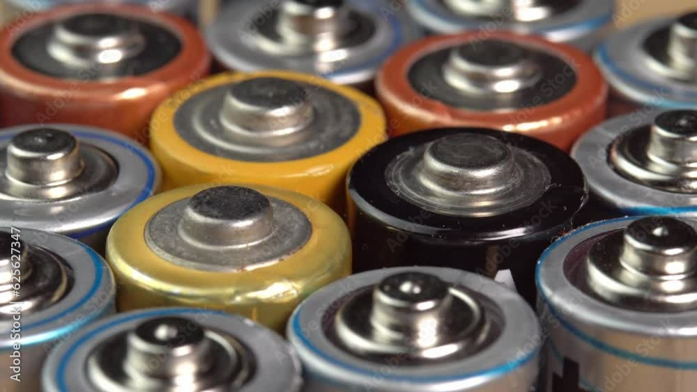 Rows of used alkaline AA batteries. Lithium ion battery pack close up. Electric power supply for electric vehicle EV. Environmental pollution, non-recyclable waste, green energy Rows of used alkaline AA batteries. Lithium ion battery pack close up. Electric power supply for electric vehicle EV. Environmental pollution, non-recyclable waste, green energy