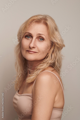 Beautiful blond middle aged woman smiling face looking camera portrait. Elegant mature lady no makeup 50 years old close-up isolated on white Women's health, cosmetology, skin care .