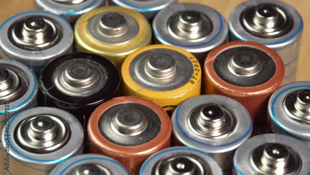 Rows of used alkaline AA batteries. Lithium ion battery pack close up. Electric power supply for electric vehicle EV. Environmental pollution, non-recyclable waste, green energy Rows of used alkaline AA batteries. Lithium ion battery pack close up. Electric power supply for electric vehicle EV. Environmental pollution, non-recyclable waste, green energy