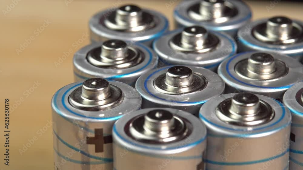 Rows of used alkaline AA batteries. Lithium ion battery pack close up. Electric power supply for electric vehicle EV. Environmental pollution, non-recyclable waste, green energy Rows of used alkaline AA batteries. Lithium ion battery pack close up. Electric power supply for electric vehicle EV. Environmental pollution, non-recyclable waste, green energy