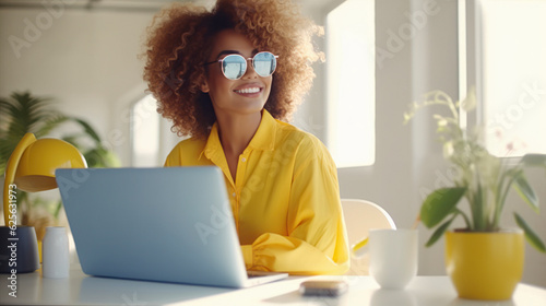 Generative AI illustration of positive black female freelancer in trendy outfit and sunglasses sitting at table with laptop while working remotely photo