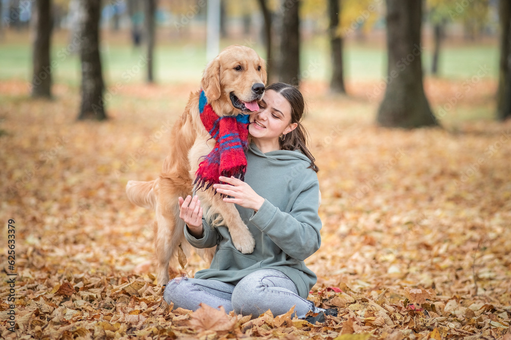 Portrait of a beautiful dark-haired girl with a golden retriever in the autumn park. Portrait of a beautiful dark-haired girl with a golden retriever in the autumn park.