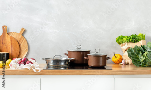 Contemporary kitchen concept or culinary background. Front view of a kitchen counter top with some utensils and culinary ingredients. Huge empty space for a text above.