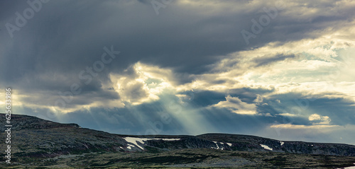 Lichtstrahlen über einem Felsgipfel in norwegen