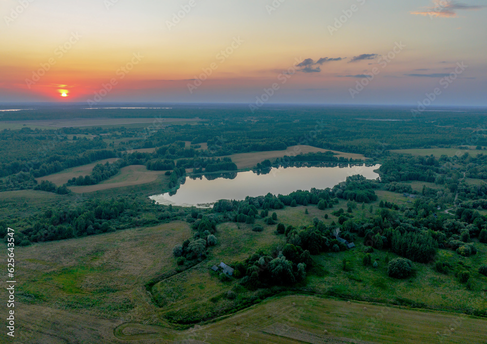 Lake in rural on sunset, drone view. Rural landscape with lakes. Drink water safe. Global drought crisis. Pond in countryside with fields. Green farm field and farmland in Country. Village at lake.